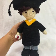 Holding the graduation doll to show its size. It stands about 8-10 inches tall.