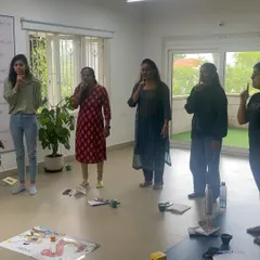 A group of educators practices the action for the 'sh' sound during our phonics training. By embodying the sounds, teachers gain a deeper understanding and are better equipped to teach them with confidence.