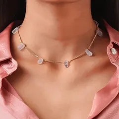 A tight close-up on a model's neck, providing a clear and detailed view of a delicate stone choker necklace.
