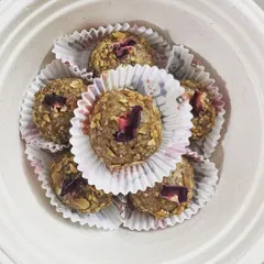A close-up of my almond and walnut laddus. These energy balls are presented in a biodegradable bowl, garnished with delicate rose petals, showcasing their handmade quality.