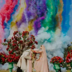 A varmala moment that feels like a painting. We used a burst of colorful smoke to create a dramatic and joyful backdrop, celebrating the couple's union in a vibrant, unforgettable way.