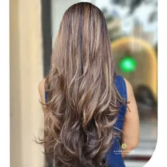 We created these beautiful, warm caramel and golden highlights on long hair, finished with layers and soft waves for a sun-kissed, dimensional look.
