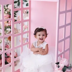 A call from a fairytale. This pink telephone booth, surrounded by beautiful blossoms, is a whimsical and charming setup for a toddler shoot. Her joyful laugh completes this magical picture.