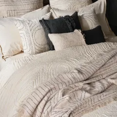 A close-up on layered bedding, emphasizing the rich textures and hand-stitched details. This type of shot is crucial for showing product quality and craftsmanship in home textile photography.