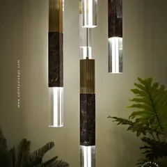 A collection of our pillar pendants, which combine sections of solid marble, fluted metal, and clear crystal. These substantial, high-quality fixtures can be hung individually or in clusters to create a dramatic effect in stairwells or entryways.