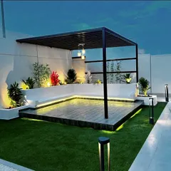 This modern rooftop terrace is transformed into a chic lounge with a sleek black metal pergola. We integrated built-in seating, a raised wooden deck, and subtle LED strip lighting to create a sophisticated ambiance perfect for evening gatherings.
