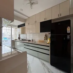 This shot captures the full expanse of the kitchen, including the ceiling fan and overhead cabinet lighting. The large window at the end brings in plenty of natural light.