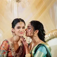 A sweet, candid moment between sisters. The makeup is designed to look soft and beautiful even in close-up, emotional shots.