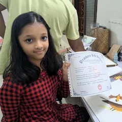 A proud moment for this young student as she receives her certificate from Pracheen Kala Kendra, recognizing her hard work and successful completion of her course level.