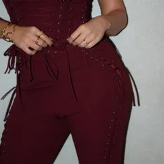 A focus on the craftsmanship. This shot highlights the intricate lace-up detailing on the custom maroon jumpsuit created by Seraphine Design Studio for Dhvani Bhanushali.