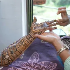 A candid moment of applying the final touches to a bridal mehndi. It's all about precision and patience to get that perfect finish.