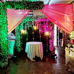 A beautiful floral canopy with hanging lights, perfect for a small Ganpati mandap or a cake-cutting ceremony at home.