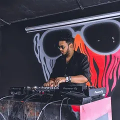 Here I am in my element, spinning at a club with some cool background art. I focus on reading the room and blending tracks seamlessly on my Pioneer DJ setup to keep the atmosphere just right.