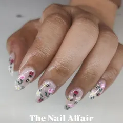 A close-up of our detailed, hand-painted nail art, featuring tiny bees, ladybugs, and flowers on a sheer nude base.