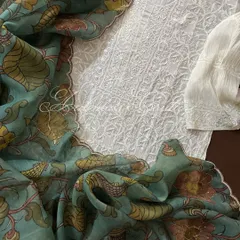 A flat-lay of the complete ensemble, showing the white Chikankari kurta, sleeve detail, and the beautifully draped Kalamkari dupatta.