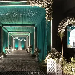 A stunning entrance tunnel designed with teal drapery and illuminated geometric arches. This modern and stylish walkway sets a sophisticated tone for guests as they arrive at a corporate cocktail party or gala.