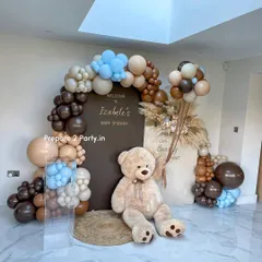 A sophisticated and modern baby shower theme with a unique color palette of brown, beige, and light blue balloons. The design includes two backdrops, pampas grass accents, and a large teddy bear for a "We Can Bearly Wait" theme.