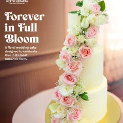 'Forever in Full Bloom' is a classic three-tiered wedding cake featuring a dramatic cascade of fresh pink and white roses. This design is all about timeless romance and making a beautiful floral statement.