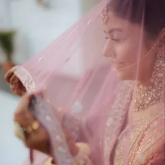 A delicate and soft portrait of bride Juhi, seen through her pink veil. We use creative techniques to capture the gentle and dreamy essence of a bride on her wedding day.