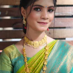 A beautiful South Indian bridal look, featuring traditional temple jewelry and a vibrant silk saree.