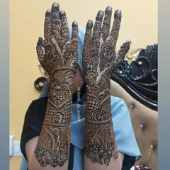 This full-arm bridal design showcases a beautiful mix of patterns. The detailed finger work, rose motifs, and geometric wristbands come together for a truly special bridal look.