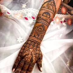 A single-arm view of a dense bridal mehandi, showcasing swans and jali (lattice) work.