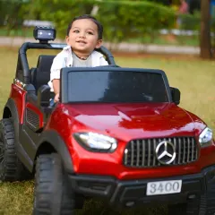 A solo shot of the little boy enjoying his ride-on Mercedes. His happy smile says it all.