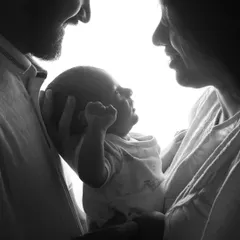 A slightly different take on the black and white silhouette, this image captures the baby looking up at their parents. The strong backlighting creates a beautiful and timeless family portrait.