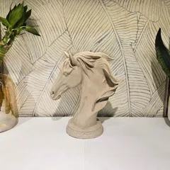 An elegant horse head bust with a smooth, stone-like finish. This classic and timeless sculpture is perfect for adding a touch of grace to a study or living room.