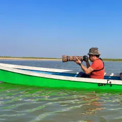On a boat in Nalsarovar, Gujarat, to get closer to the wetland birds. Accessing remote areas is often necessary to photograph shy species in their natural habitat.