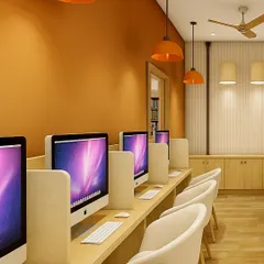 This digital workspace at Queen’s College, Indore, was designed for focus and ergonomic comfort. The bold terracotta accent wall and matching pendant lights energize the space, while the light wood desks and privacy panels ensure a functional study environment.