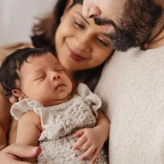The quiet, powerful love of new parents. This intimate close-up captures a mother and father cherishing their sleeping newborn, showcasing the soft, emotional style of my newborn family portraits.