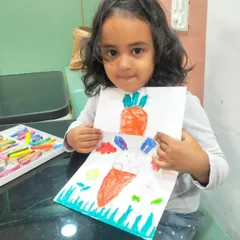 This young artist proudly displays her clever carrot and bunny drawing. It's a simple paper craft that combines drawing, coloring, and a fun surprise element.