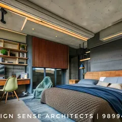 This bedroom showcases a modern, industrial aesthetic with exposed concrete ceilings and warm wood accents. We designed this space in a Pioneer Araya apartment to be a functional retreat, complete with a built-in desk, ample shelving, and layered lighting to create a cozy yet sophisticated atmosphere.