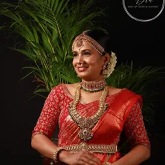 This professionally captured photo showcases a complete South Indian bridal look. The makeup is designed to be bold yet elegant, with defined eyes and a warm lip colour that enhances the bride's features. Paired with an elaborate hairstyle and antique jewellery, this is a classic look for any traditional wedding ceremony.