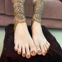 This is the first step in a detailed leg mehendi design, showing the cuff or anklet pattern being created.