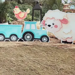 A cute cutout of a sheep next to a blue tractor. These props were scattered around the party area to make the entire space feel like a fun and friendly farm.