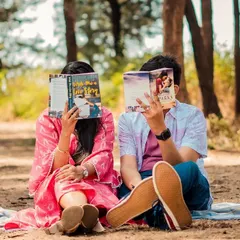 A playful shot of the couple hiding behind their books, a fun and creative idea for a themed session.