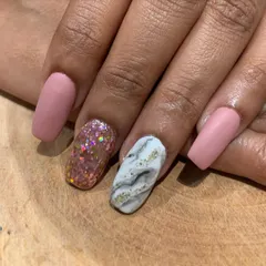 A close-up of this mixed-texture matte set. It combines a soft pink matte polish with a chunky glitter accent and a white and gold marble nail.