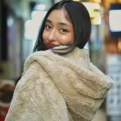 A playful over the shoulder look. The blurred lights of the market street create a beautiful bokeh that makes this night portrait feel magical and alive.