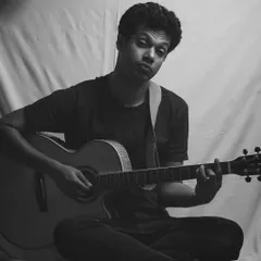 A self-portrait with my guitar. I also enjoy photography, and sometimes I turn the camera on myself to capture a mood. This was a high-key lighting setup.