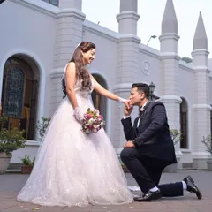 The perfect proposal moment. The groom-to-be gets on one knee for his bride, who looks like a princess in her white wedding ball gown.