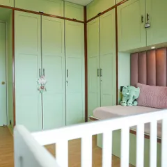 We love when clients embrace gender-neutral colors. This nursery features beautiful mint green shaker-style wardrobes that provide ample storage for a growing child.