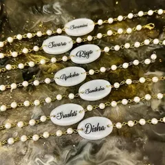 For Raksha Bandhan, I create these beautiful unisex rakhi bracelets with personalized nameplates set in resin, surrounded by pearl and gold-colored beads.