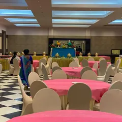 The dining hall at CMA Palace set up for a wedding reception. The vibrant pink tablecloths and clean white chair covers create a cheerful and welcoming atmosphere for guests before the festivities begin.