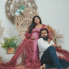 A cozy and elegant studio setup is perfect for intimate maternity portraits. The focus is completely on the couple and the beautiful baby bump.