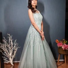 A side profile of a model in the blue gown, highlighting the delicate details on the bodice.