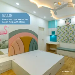 This bedroom showcases a rainbow-themed headboard and a calming blue color scheme to promote concentration and sleep. The design includes under-bed storage drawers and a matching study area, creating a cohesive and practical space.