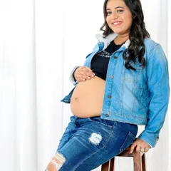 A solo portrait that's cool, confident, and modern. A denim jacket and ripped jeans are a great way to show off your personal style during your maternity shoot.