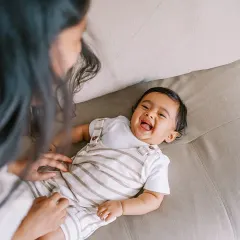 The purest giggle. This candid shot of a baby laughing while playing with his mom on the couch is what lifestyle sessions are all about.